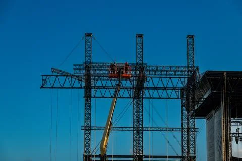 Workers assembling stage truss on mobile platform Stockfoto's