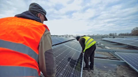 Workers attach photovoltaic panel. Construction of innovative solar energy farm Stock-Footage 130018497