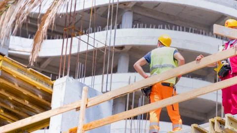 Workers on the background of a high-rise building under construction Stock Photos