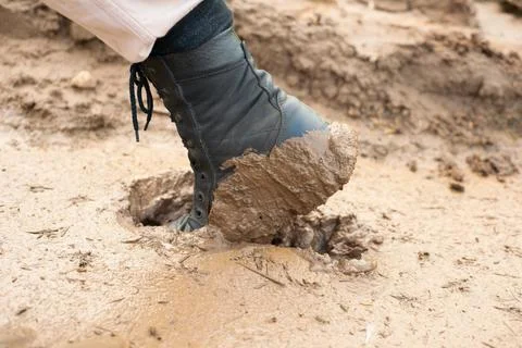 The worker's black boot was stuck in the mud Stock Photos