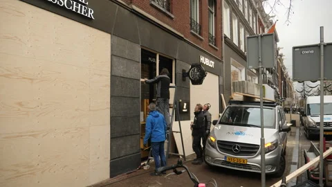 Workers boarding up a luxury store to prevent looting. Amsterdam, Netherlands. Stock Footage 147944203