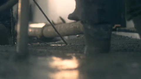 Workers in boots creates a smooth surface from concrete mass Stock Footage 130260747