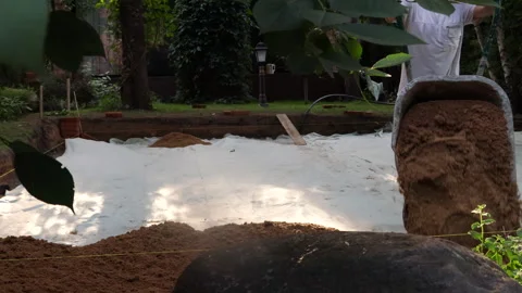 Workers bring sand in wheelbarrows to prepare the foundation Stock Footage 279333948