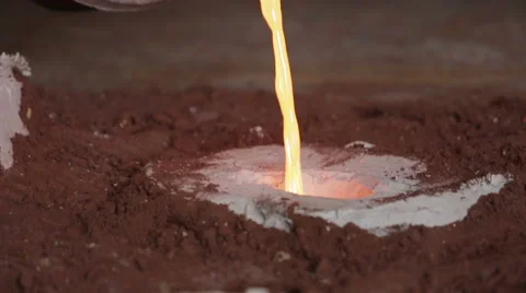 Workers in a bronze foundry pouring bronze into investments for a bronze statue Stock Footage 58639409