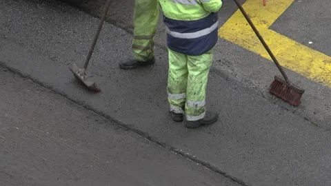 Workers with broom take a break during asphalt road repair Video stock 166635435