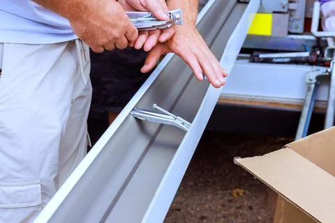 Workers build install metal structures to gutter for construction project Stock Photos