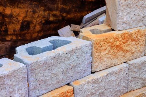 Workers build structure using concrete blocks at construction site in busy ci Stock Photos