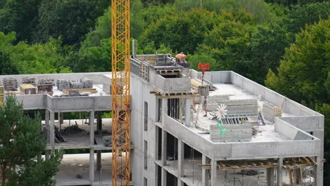 Workers build the top floor of a modern concrete residential building Stock Footage 346181786