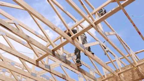 Workers build wooden frame structure during construction project Video stock 337493068