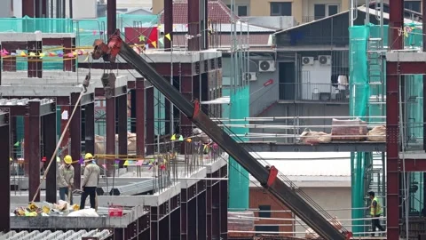 Workers at a building construction site are using a crane Stock Footage 310178854