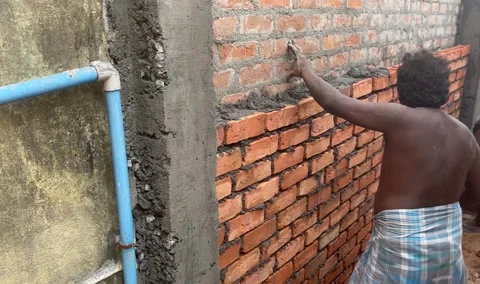Workers building side wall known as compound wall Stock Footage 274396415
