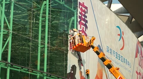Workers in the cable car on high altitude demolition advertising signs Stock Footage 46130968