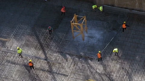 Workers carefully carry reinforcement bars at construction site Stock Footage 236474064