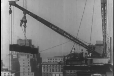 Workers carry huge structural beam during building construction - 1930 Stock Footage 104336501