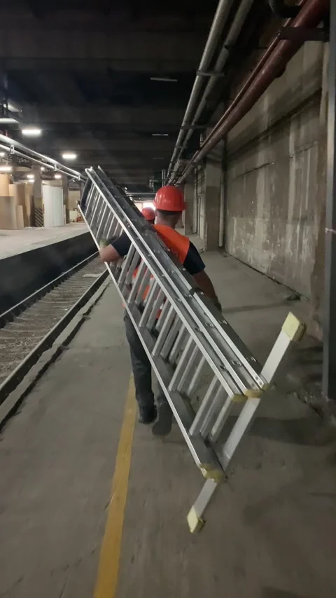 Workers carry ladder in industrial facility to restore fiber optic cables. Video stock 346298756