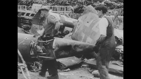 Workers carry off scrapped German planes and antiaircraft batteries scan the Stock Footage 103376887