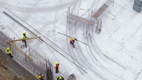 Workers carrying steel bars at the construction site, concrete background Stock Footage 236474155