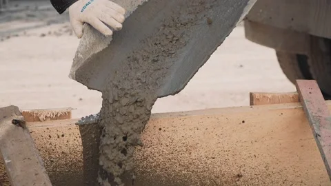 Workers cement mortar from the concrete mixer machine into the container Stock Footage 146692922