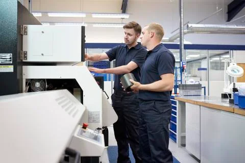 Workers checking control panel in engineering factory Foto stock