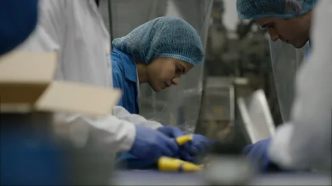Workers checking cosmetics before packingm in boxes in factory Stock Footage 107992062