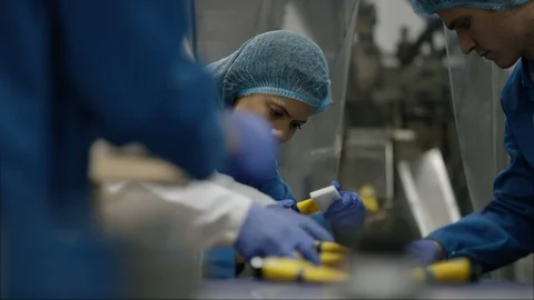 Workers checking cosmetics before packingm in boxes in factory Stock Footage 107992121
