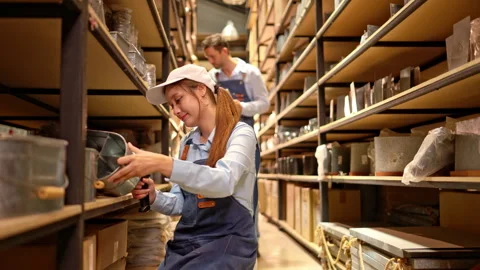Workers checking inventory in a warehouse using a tablet for efficient stock Stock Footage 339641741