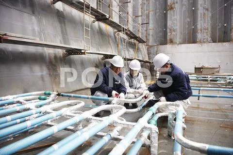 Workers Checking Pipework On Container Ship At Shipyard, Goseong-Gun, South