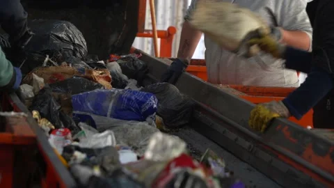 Workers classify and separate the waste on a conveyor belt inside a waste Stock Footage 204892713