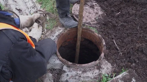 Workers clean manhole and take out dirt Stock Footage 103350182