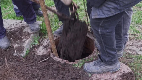 Workers clean the manhole and take out dirt with a shovel Stock Footage 103350312