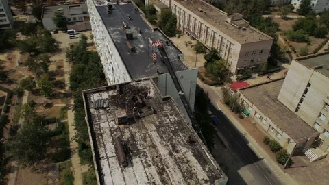 Workers clean the roof of a multi-storey building from an old roofing felt. Stock-Footage 93965495
