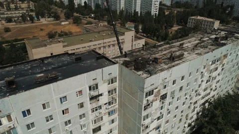 Workers clean the roof of a multi-storey building from an old roofing felt. Stock-Footage 93966147