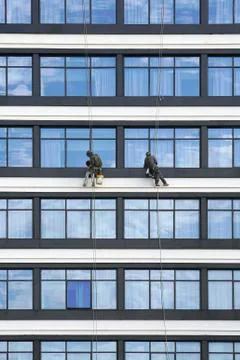 Workers clean the windows on the skyscrapers Stock Photos