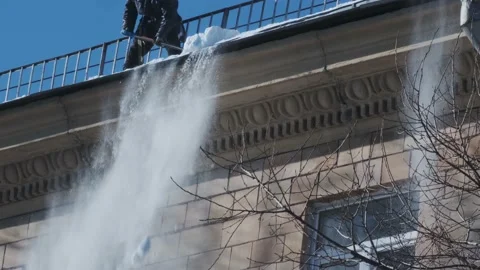 Workers cleaning and dumping snow and ice from roofs in the city. Winter city Vídeo Stock 188569147
