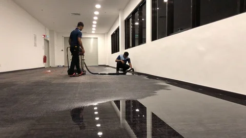 Workers cleaning the carpets filled with water using vacuum. Stock Footage 97710289