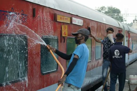 Workers cleaning train, wearing face mask. Stock Photos