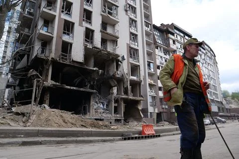 Workers clear rubble after bombing. Dwelling house damaged by russian missile Stock Photos