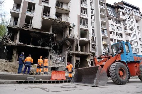 Workers clear rubble after bombing. Dwelling house damaged by russian missile 스톡 사진