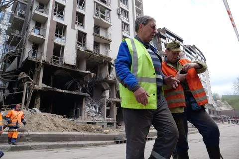 Workers clear rubble after bombing. Dwelling house damaged by russian missile Foto stock