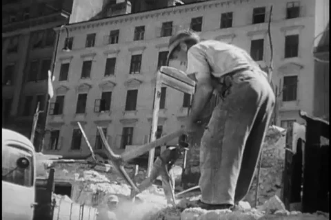 Workers clear rubble and men work on scaffolding of a building - 1950 Stock Footage 105704296