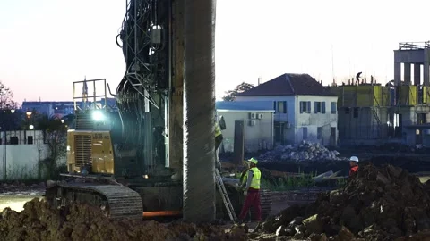 Workers climb the stairs to the drilling machine near the installed pile Stock Footage 269245493