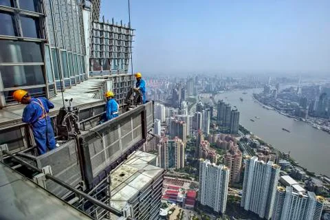 Workers climbing onto a scaffold in a skyscraper Stock Photos