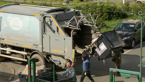Workers collecting garbage and trash containers into garbage truck Stock Footage 154635656