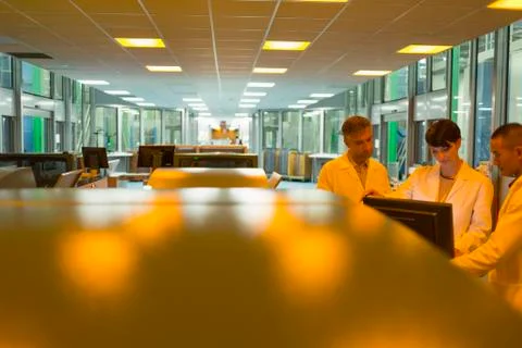 Workers at computer near printers in factory Stock Photos