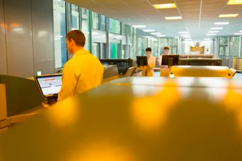 Workers at computers among printers in printing plant Stock Photos