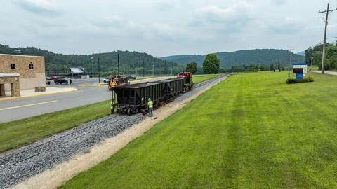 Workers Conduct Maintenance on a Train Track Near a Small Town in the Count.. Stockfoto's