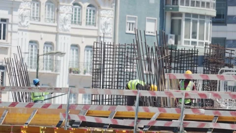 Workers construct a building at a construction site in a city during the day Vídeos de archivo 338245914