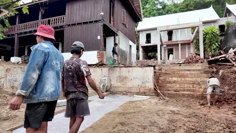 Workers constructing and renovating residential buildings at a building site in Stock Footage 325326647