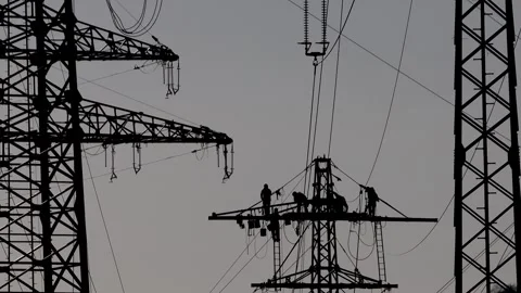 Workers constructing a high voltage power line silhouetted against the backgr Stock-Footage 330243034