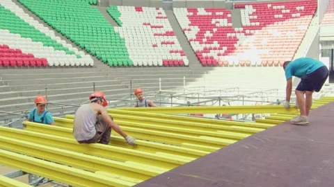 Workers constructing yellow frame beams under path level Stock Footage 236473627